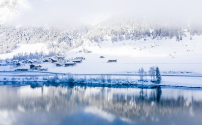 lake-by-snow-covered-hills-captured-foggy-day.jpg
